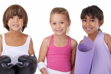 Three Young Children Enjoying Homeschool Pe With Fun And Fit Boxing Gloves.