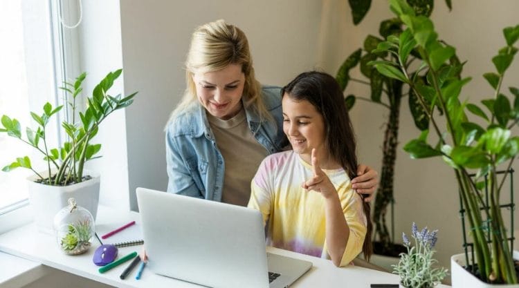 A Mother And Daughter Working On A Laptop At Home.