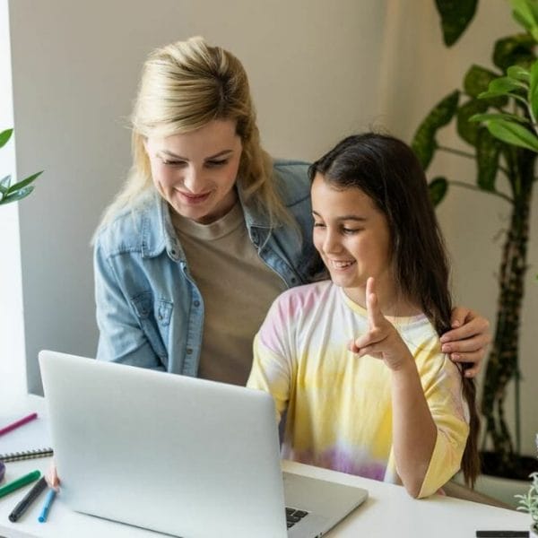 A Mother And Daughter Working On A Laptop At Home.