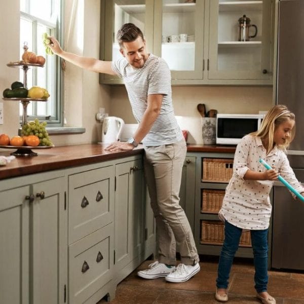 A Man And A Little Girl Cleaning A Kitchen.